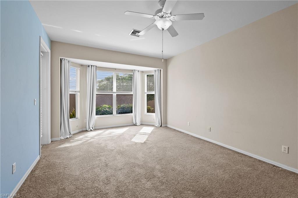 Carpeted Primary Bedroom featuring baseboards and a ceiling fan