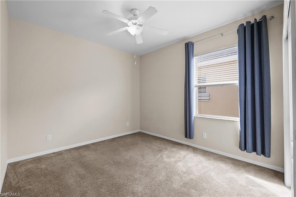 Bedroom with light carpet and a ceiling fan