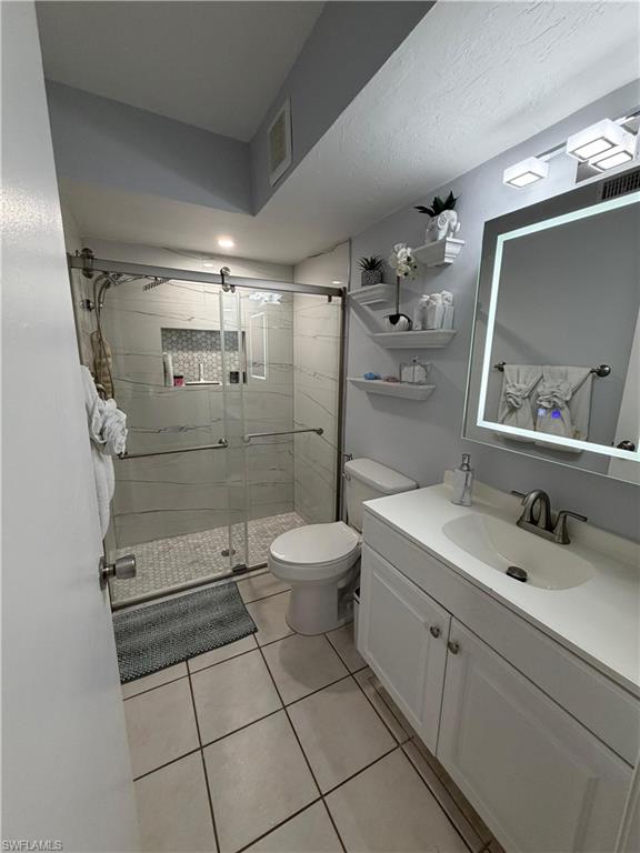 Bathroom featuring a walk-in shower with glass enclosure, white subway tile walls, and a mosaic accent