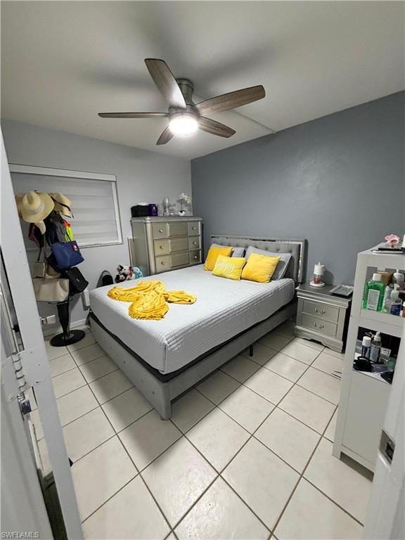 Room featuring light tile flooring and a ceiling fan with integrated lighting