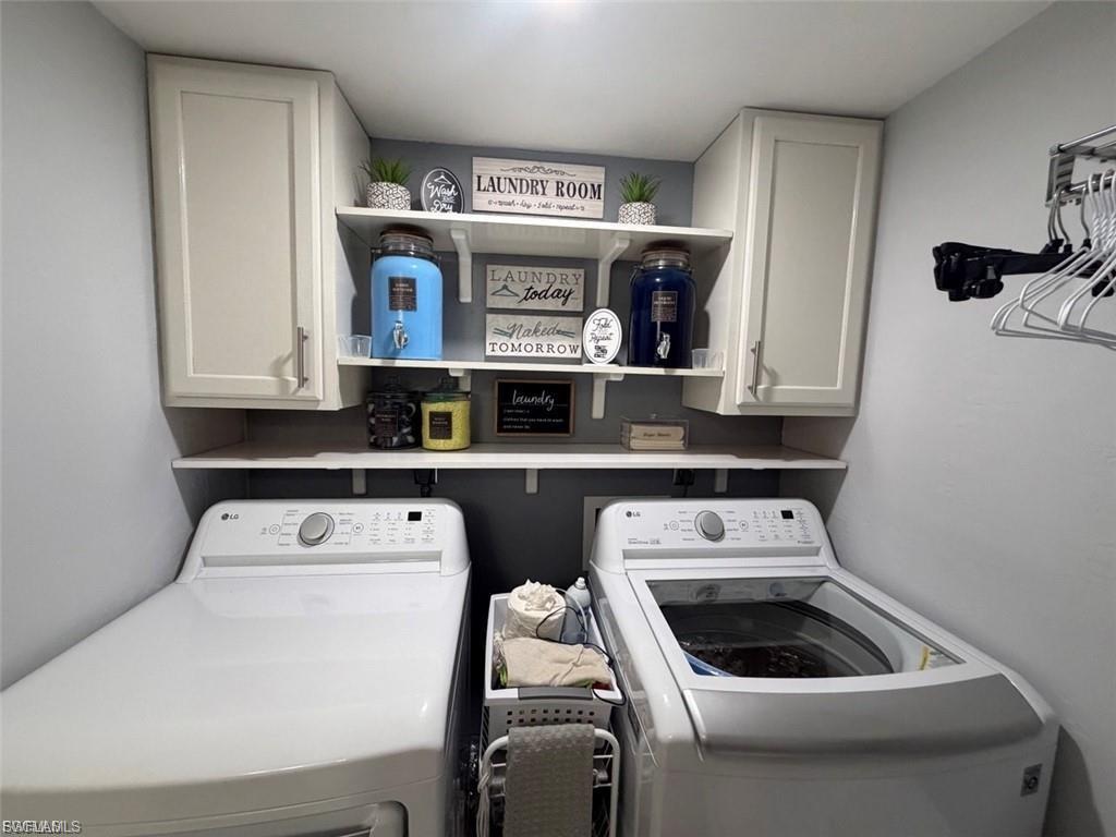 Dedicated laundry space featuring a side-by-side appliance configuration, white upper cabinetry with brushed nickel hardware, open shelving, and a built-in hanging rack