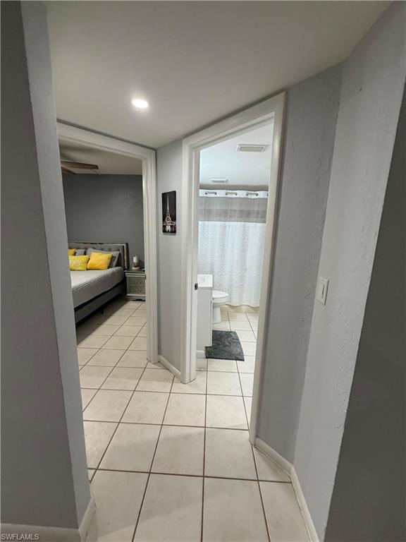 Hallway featuring tile flooring and light grey wall paint