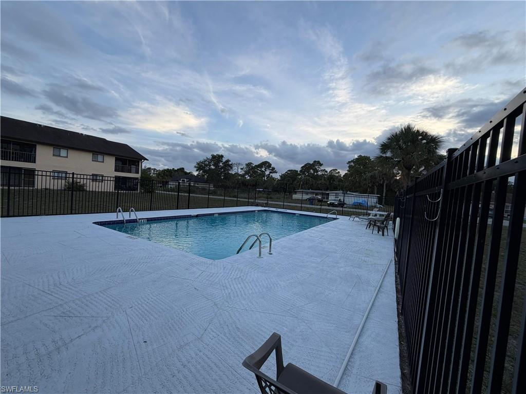 Rectangular swimming pool featuring a light-colored, textured deck surround and metal access ladders