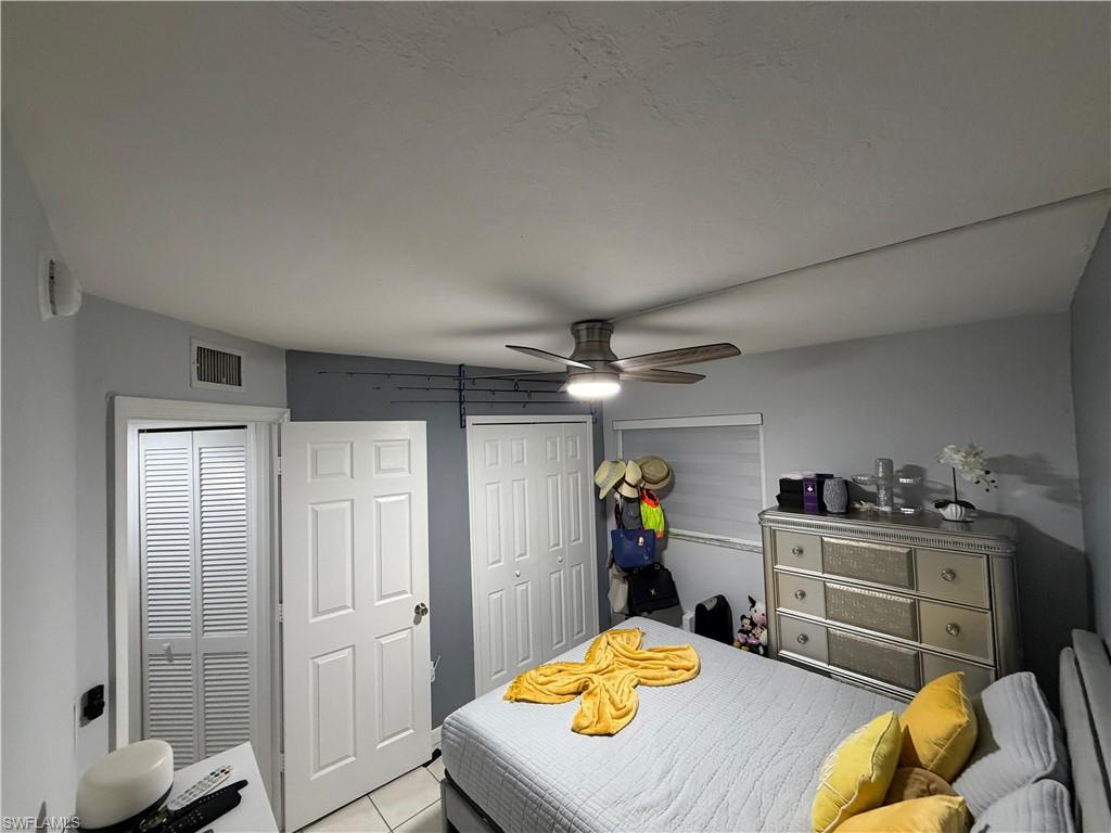 Interior room featuring a ceiling fan with integrated lighting, a paneled door, and louvered bifold closet doors