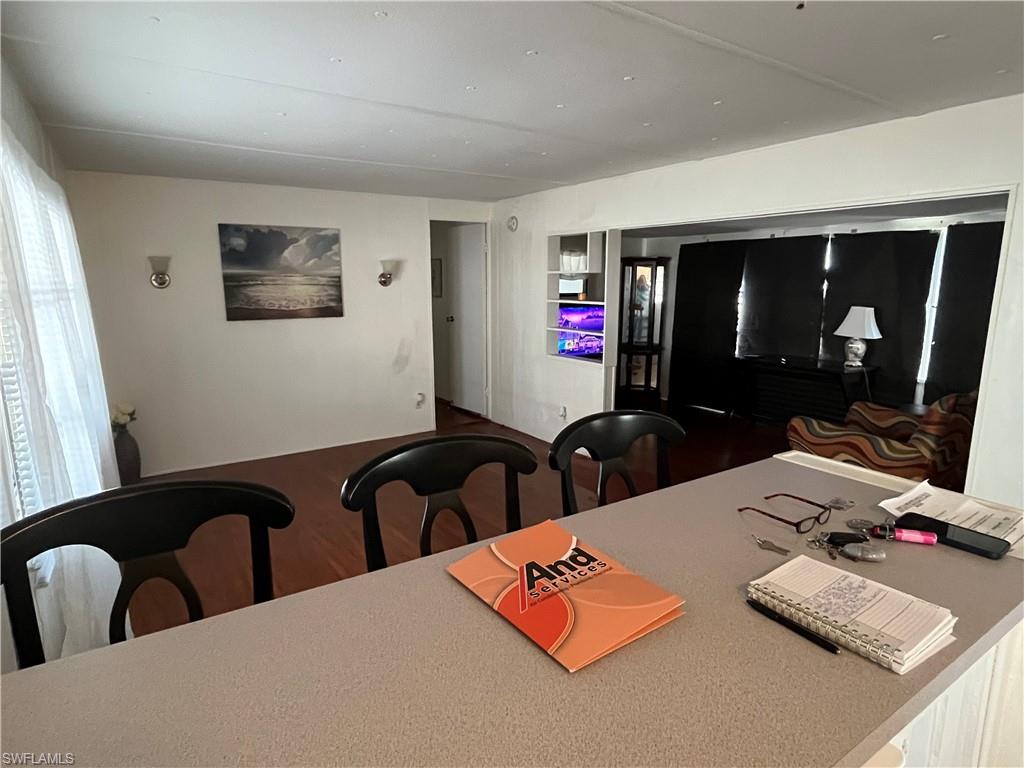 Open concept living area featuring wood-finish flooring, and attached island/bar