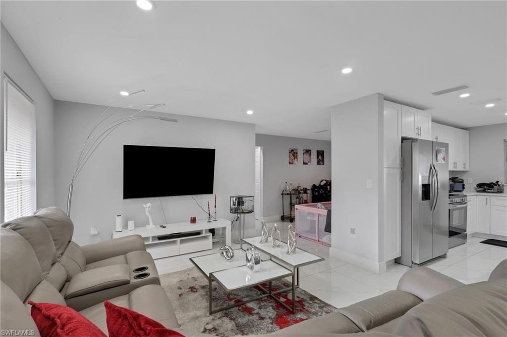 Open-concept living space featuring recessed lighting, light-toned walls, and white tile flooring