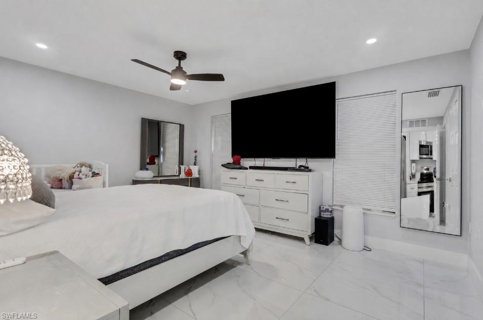 Spacious room featuring light-toned walls and large format tile flooring