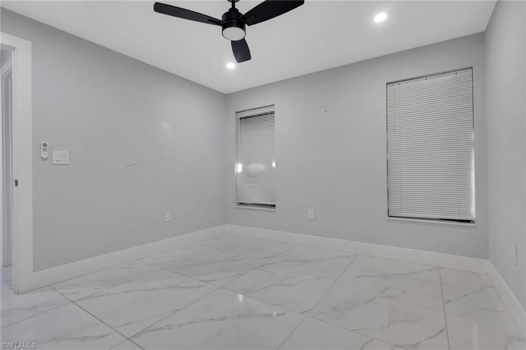 Room featuring large format porcelain tile flooring, two windows with horizontal blinds, recessed lighting, and a ceiling fan