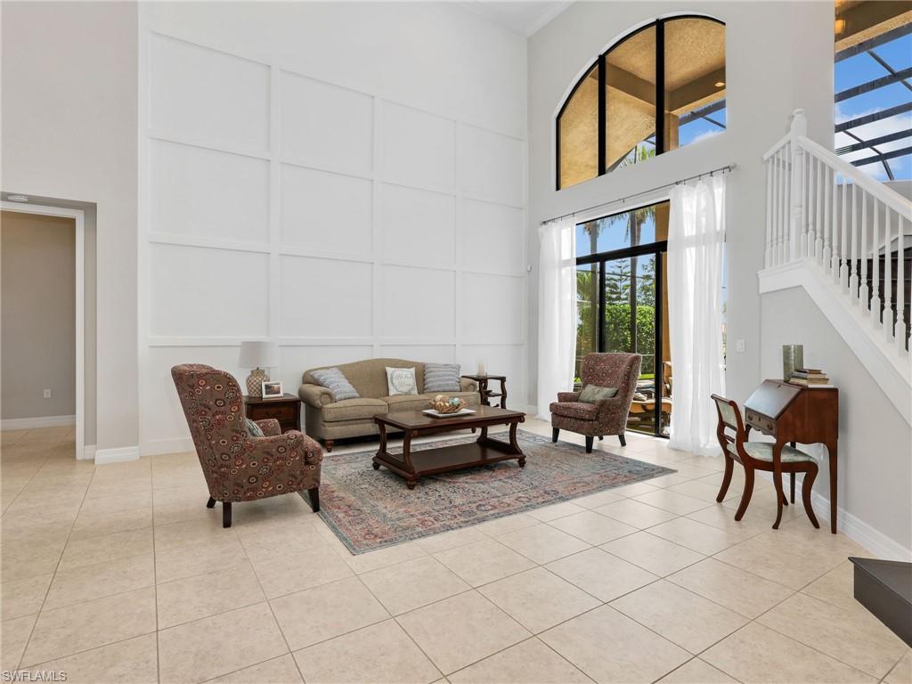Two-story living area featuring a vaulted ceiling and a decorative accent wall