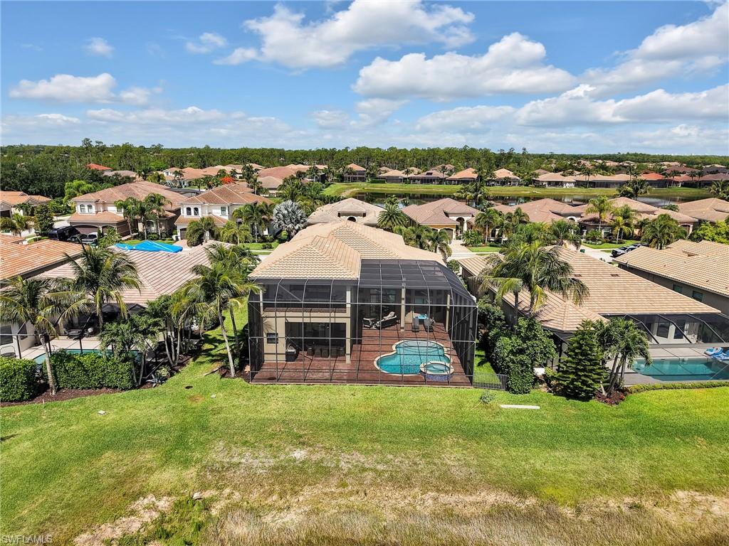 Screened lanai encompassing a swimming pool and attached spa, with a surrounding wood-finish deck