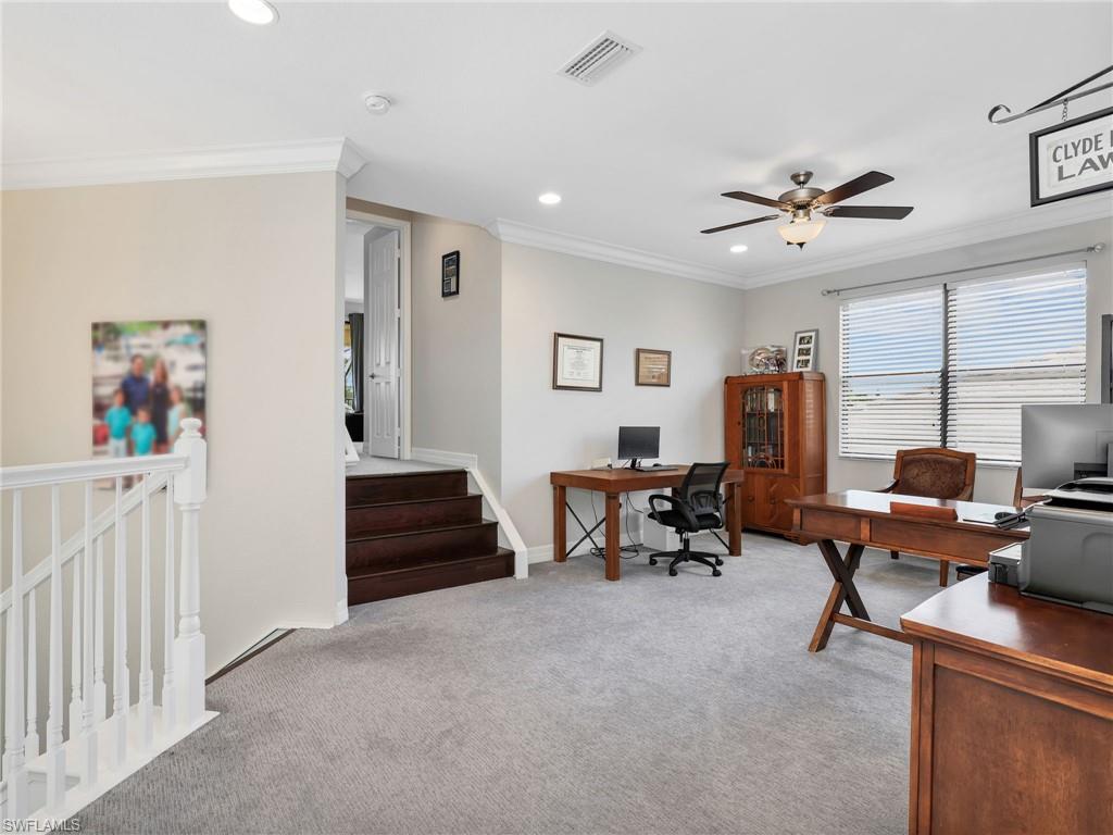 Spacious carpeted loft featuring a ceiling fan with light fixture, recessed lighting, and crown molding