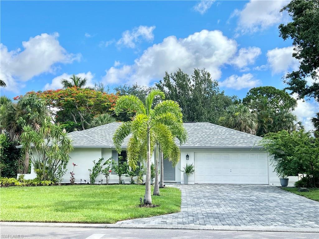 Contemporary single-story residence featuring a gray shingle roof and a paver driveway