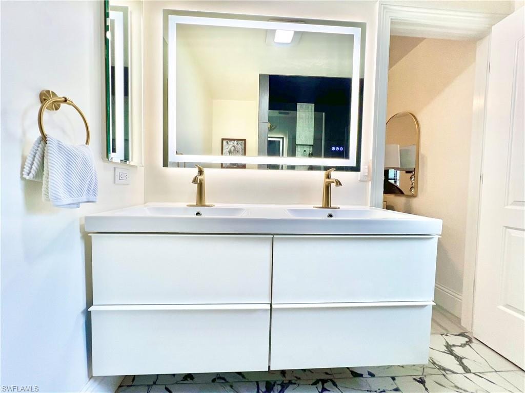 Dual vanity with integrated sinks and wall-mounted gold-finish faucets