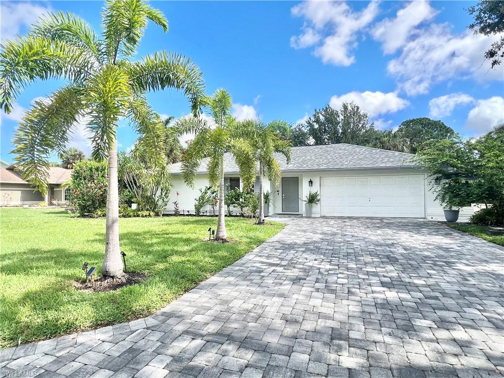 Contemporary exterior featuring a paver driveway, an attached garage, and a grey shingle roof