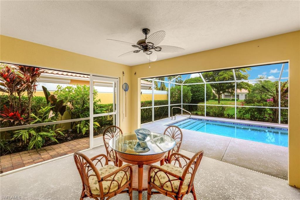 Screened patio featuring an in-ground swimming pool, concrete decking, and lush landscaping