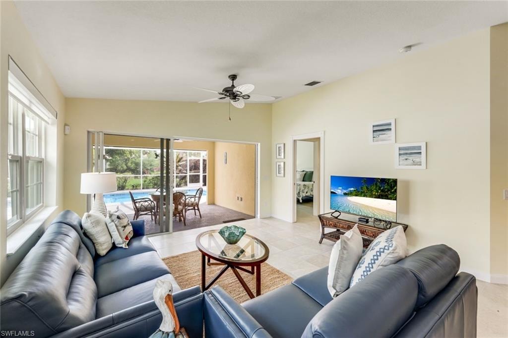 Open-concept living space featuring light-toned tile flooring and vaulted ceilings