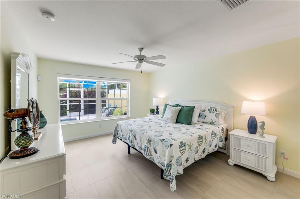 Spacious room featuring light-toned flooring, a ceiling fan, and large windows with exterior visibility