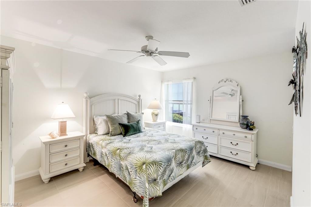 Bright room featuring light-toned flooring, white walls, and a ceiling fan with integrated lighting