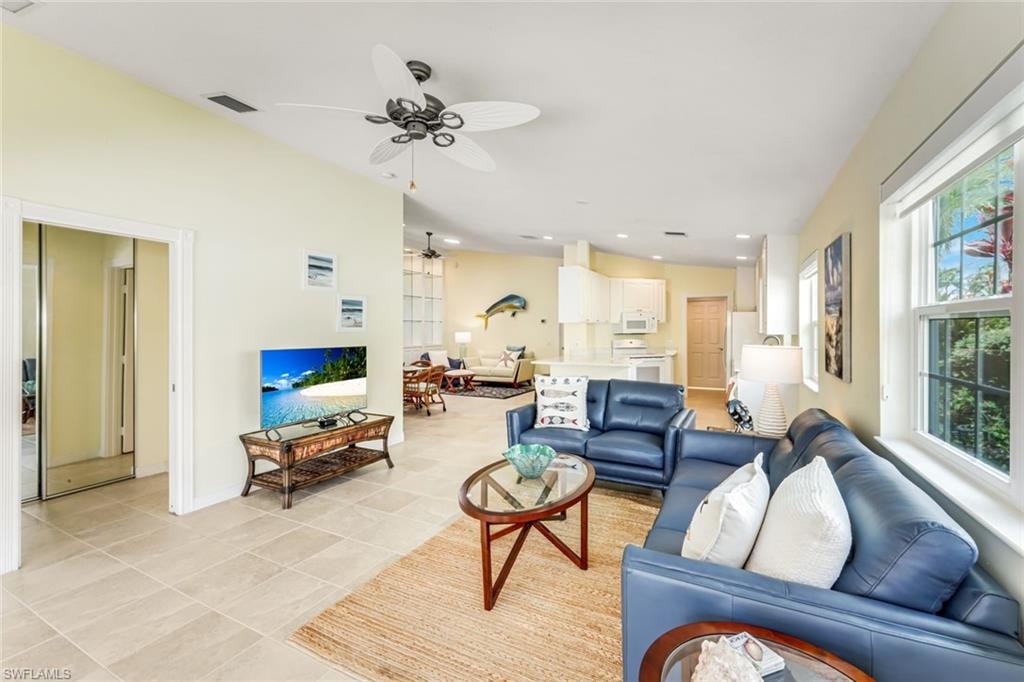 Open-concept living area featuring tile flooring, high ceilings, and a ceiling fan