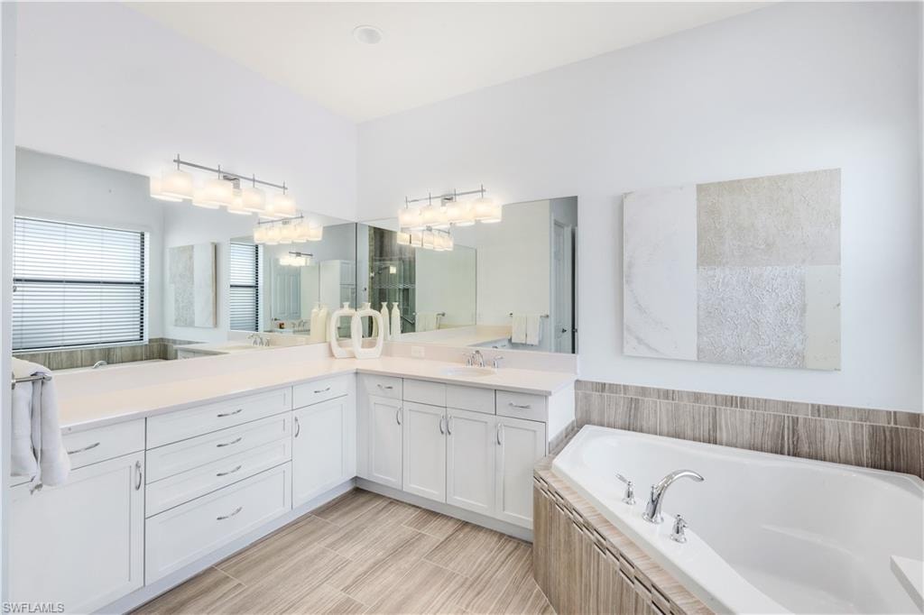 Primary bathroom with glass enclosed shower, dual sinks and tub.