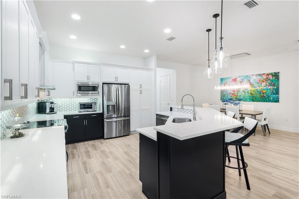 Fully renovated kitchen with stainless steel appliances, quartz countertops and custom backsplash.