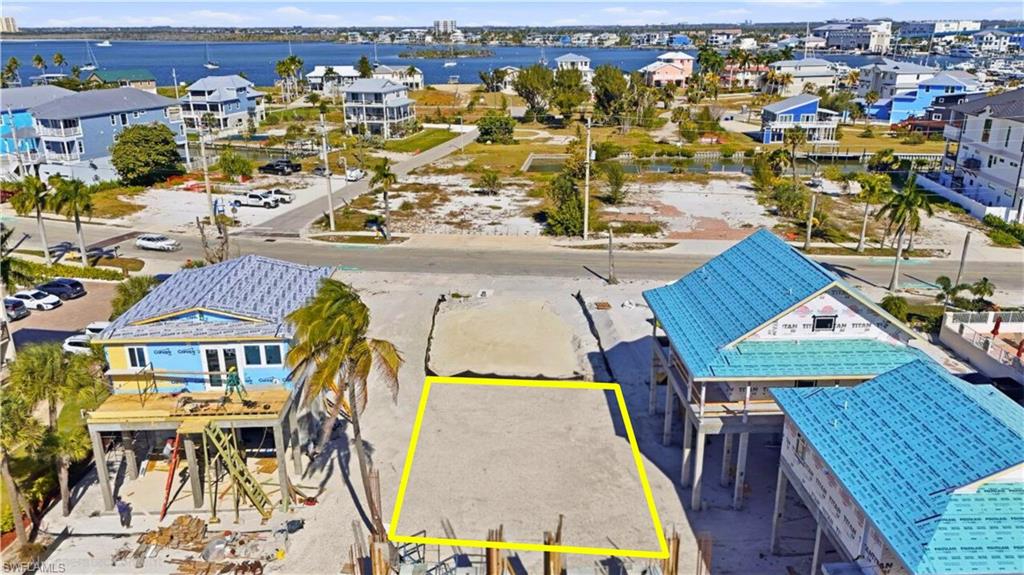 Aerial perspective of suburban area with a nearby body of water and property parcel outlined - Virtually Edited Image