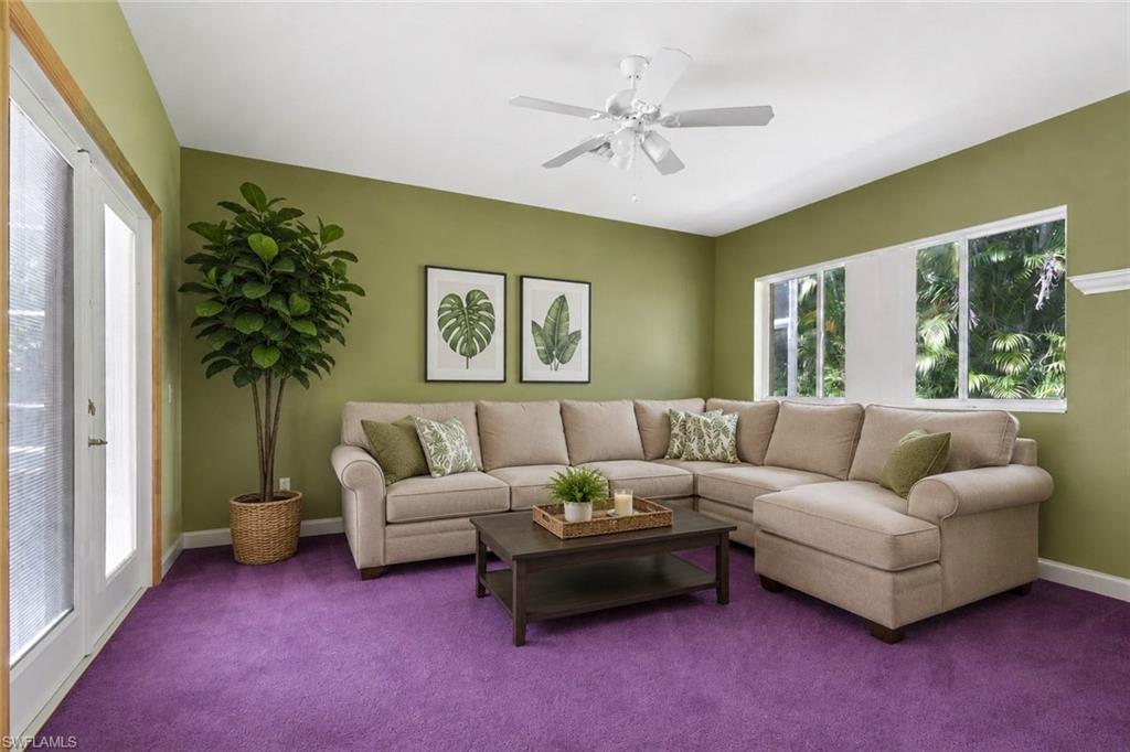 Staged Spacious living Bedroom that goes out to the pool, featuring vibrant purple carpeting, olive green walls, and white ceiling