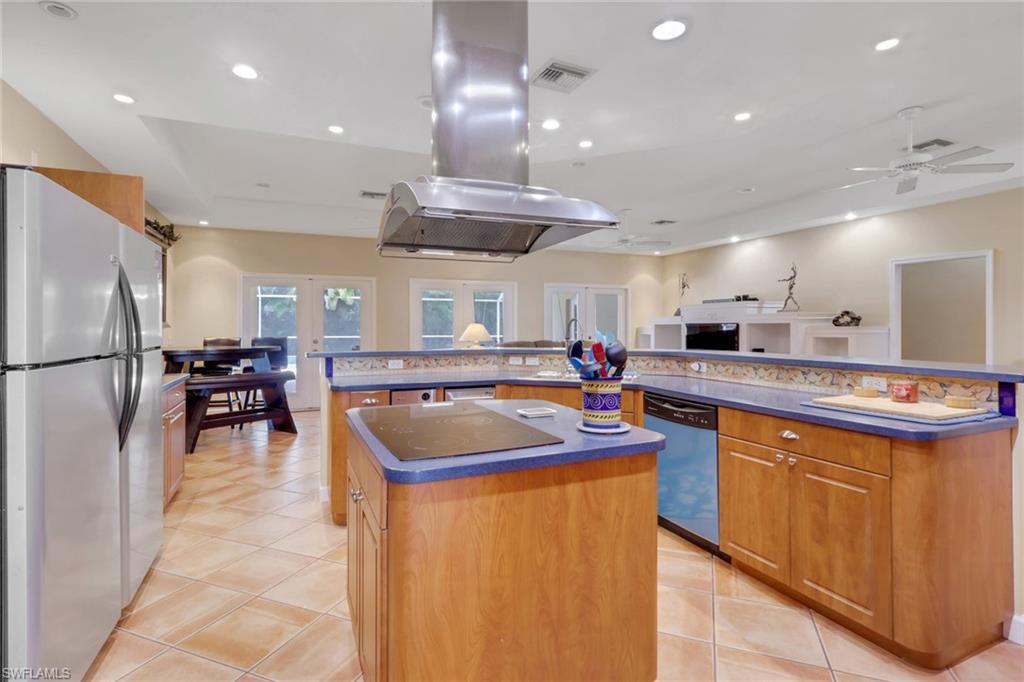 Kitchen featuring stainless steel appliances, wood-finish cabinetry, tile flooring, and recessed lighting