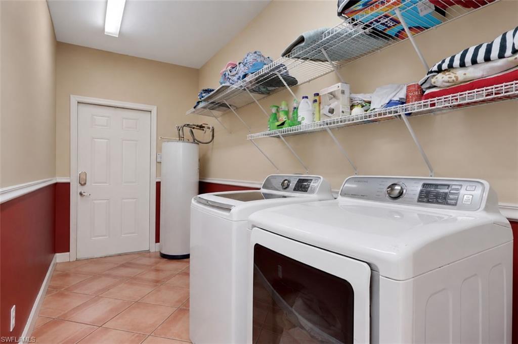 Laundry room featuring tiled flooring, a white paneled door, and two rows of built-in wire shelving