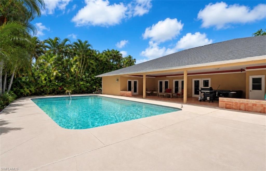 Expansive outdoor area featuring a rectangular swimming pool with surrounding concrete decking