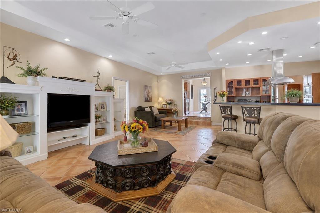 Spacious open-concept living area featuring a built-in entertainment center, recessed lighting, and tile flooring
