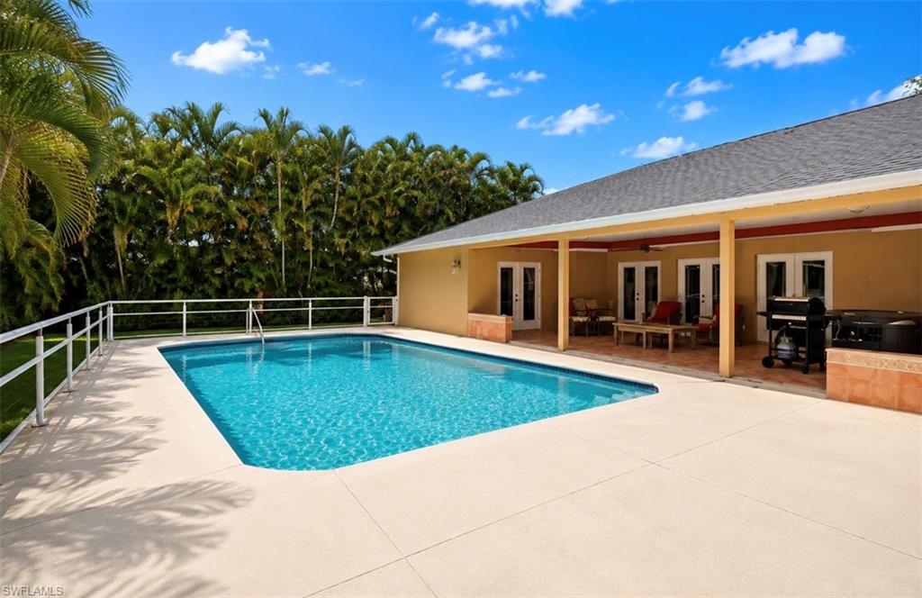 Rectangular swimming pool surrounded by a light-colored concrete deck