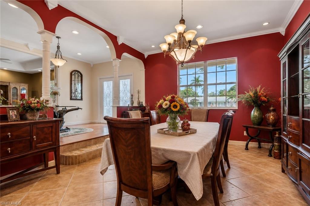 Dining area featuring tile flooring, a multi-pane window, and a prominent chandelier