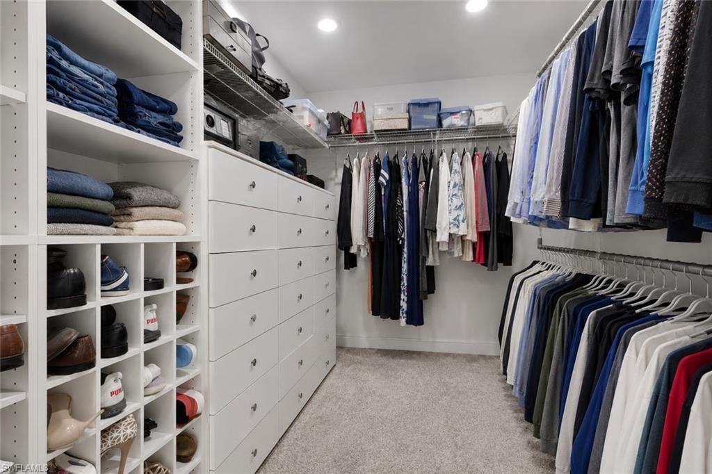 Custom closet system featuring extensive shelving, built-in drawer units, shoe cubbies, and multiple hanging rods