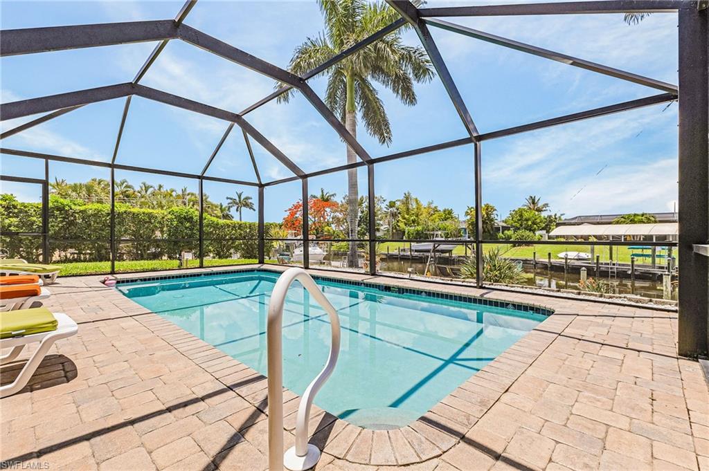 Pool area with newer pool cage and pavers for easy living