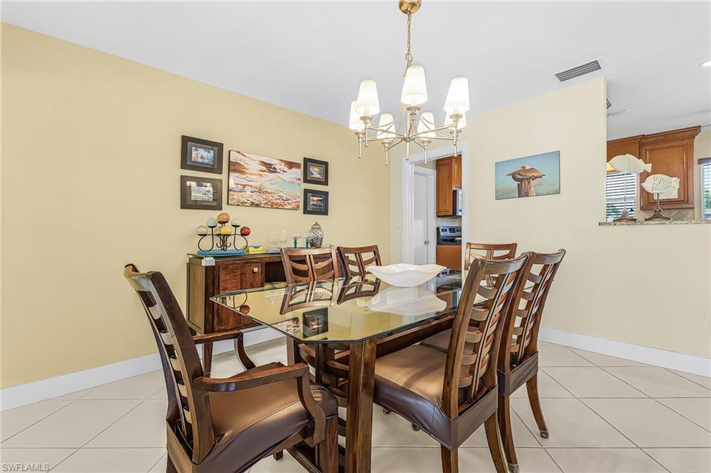 Great room dining area with door to kitchen and pocket sliders to the pool area