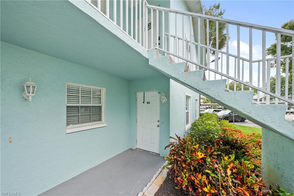 Ground-floor unit entry featuring a white door and an exterior wall light fixture