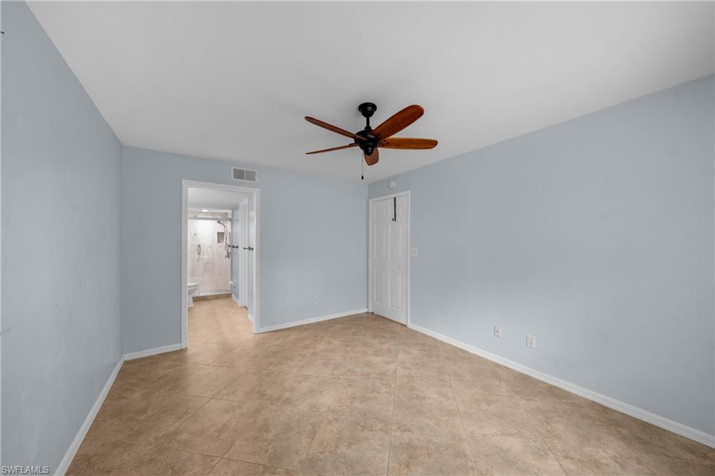 Spacious interior room featuring light blue walls and neutral tile flooring