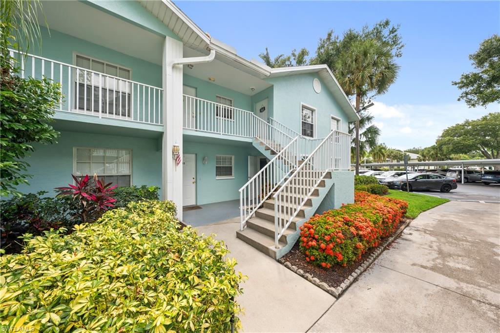 Two-story building featuring light blue stucco exterior and white railings