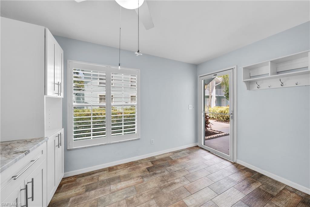 Light-filled room featuring wood-finish flooring and a ceiling fan