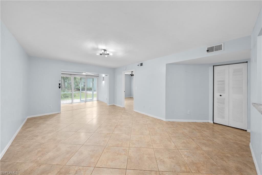 Spacious interior featuring neutral-toned tile flooring, light-colored wall paint, and white trim