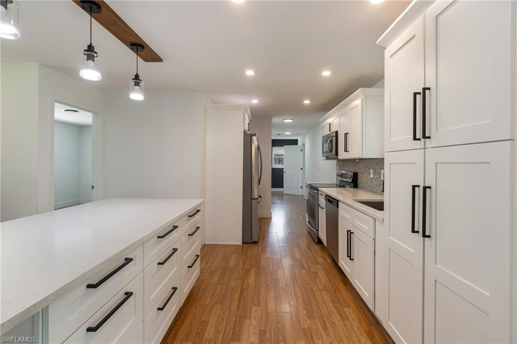 Modern kitchen featuring an expansive central island with a light-toned countertop and ample storage
