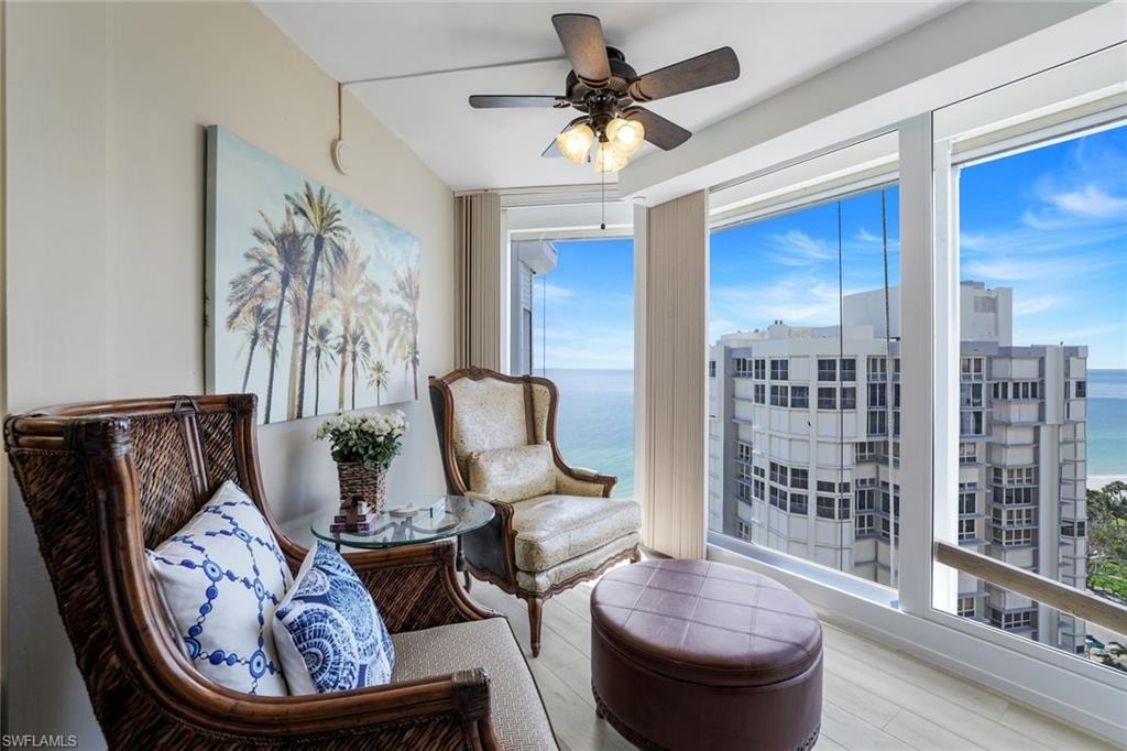 Sitting room featuring plenty of natural light, ceiling fan, wood finished floors, and a water view