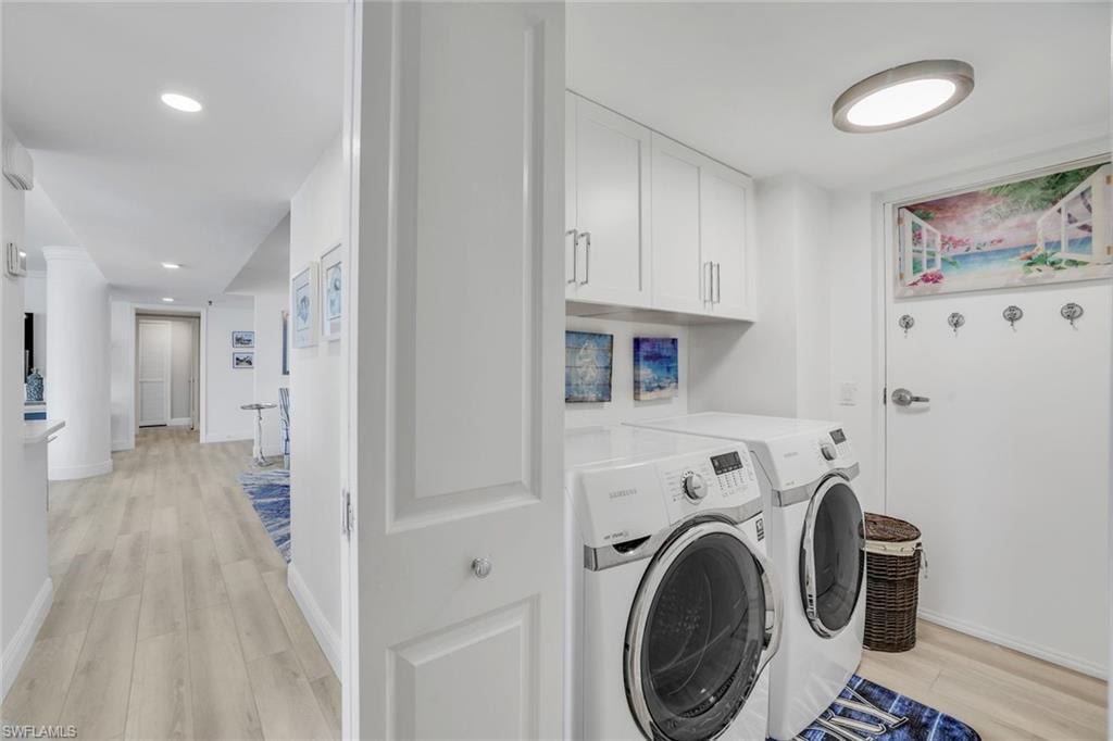Washroom with washer and clothes dryer, light wood-type flooring, cabinet space, baseboards, and recessed lighting