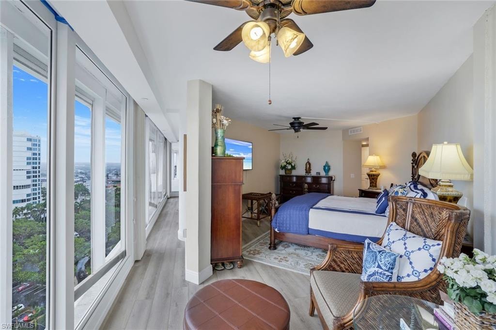 Bedroom with multiple windows, light wood-type flooring, and a ceiling fan