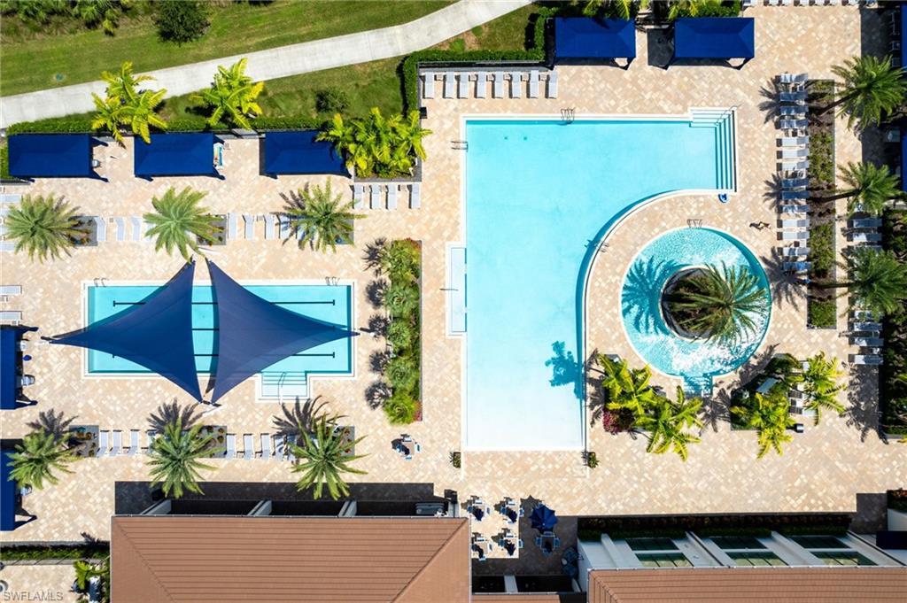 Expansive aquatic area featuring two distinct pools, a circular spa, and surrounding paver decking