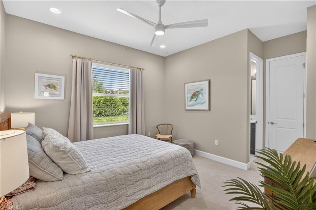 Carpeted interior space featuring a window with exterior shrubbery, recessed lighting, and a ceiling fan