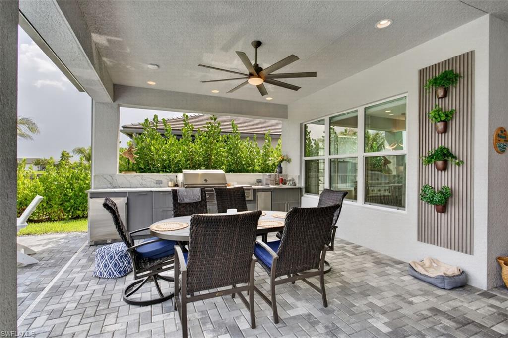 Covered outdoor patio featuring a ceiling fan, recessed lighting, and herringbone-patterned paver flooring