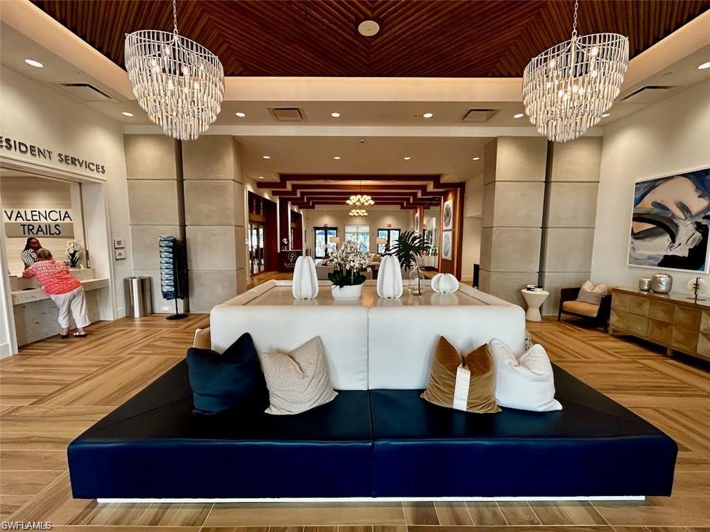 Grand interior lobby featuring a chevron pattern wood-finish floor and a slatted wood-panel ceiling