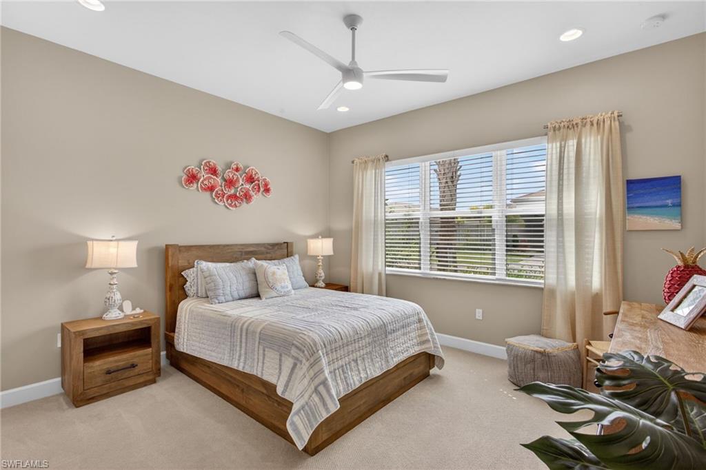 Carpeted bedroom featuring a large window with blinds, a ceiling fan with integrated lighting, and recessed lighting